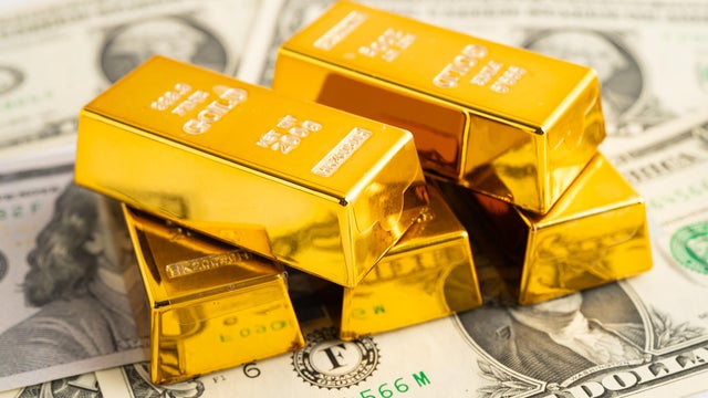 Gold bars with US dollar banknote money, finance trading investment business currency. 