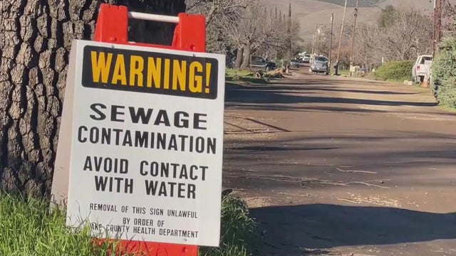A sign warning people about a sewage spill in the area 