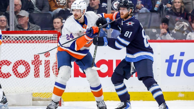 Scott Mayfield #24 of the New York Islanders and Kyle Connor #81 of the Winnipeg Jets battle for position as they keep an eye on first period action at the Canada Life Centre on January 13, 2026 in Winnipeg, Manitoba, Canada. 