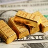 Gold bars on US dollar banknote money, finance trading investment business currency concept. 