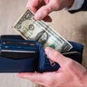 Person Handling Cash and Cards in Blue Leather Wallet 