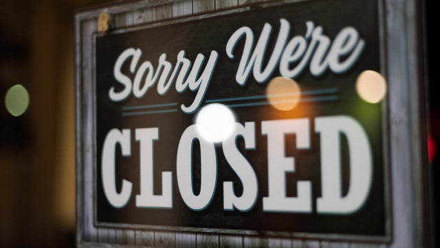 closed sign hanging on door of retail establishment 