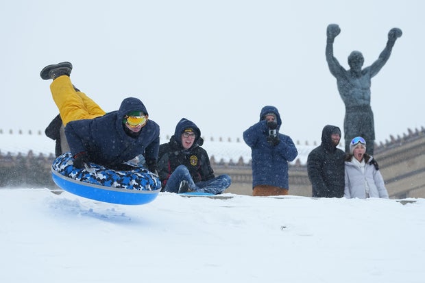 People sled near the Rocky Statue at the top of the Philadelphia Art Museum steps 