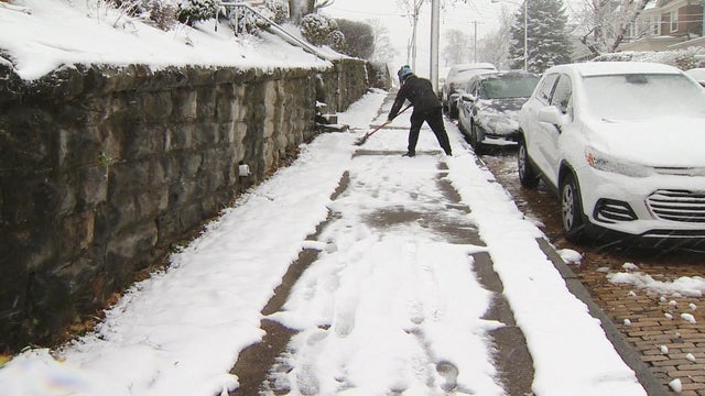 File photo of someone shoveling a sidewalk 