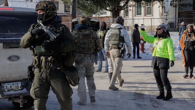 Community members are confronted by armed federal agents conducting immigration enforcement operations in a neighborhood in Minneapolis, Minnesota,  on Jan. 23, 2026. 