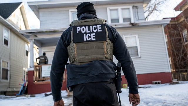 A federal law enforcement agent outside a home during an ICE immigration raid in south Minneapolis 