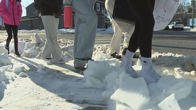 Students cross a snowy intersection in Gloucester City on their way to school 