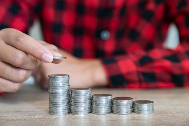 Saving money. Female hand stack coins to shown concept of growing business and wealthy.