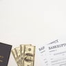 top view of bankruptcy papers, law book and money on white background 