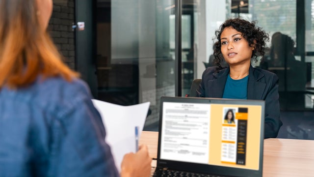 Recruiter holding candidate resume taking job interview at desk. 