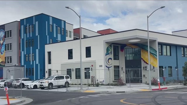 an apartment complex behind a chain link fence 