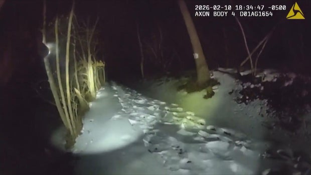 Body cam footage shows a snowy path in a wooded area
