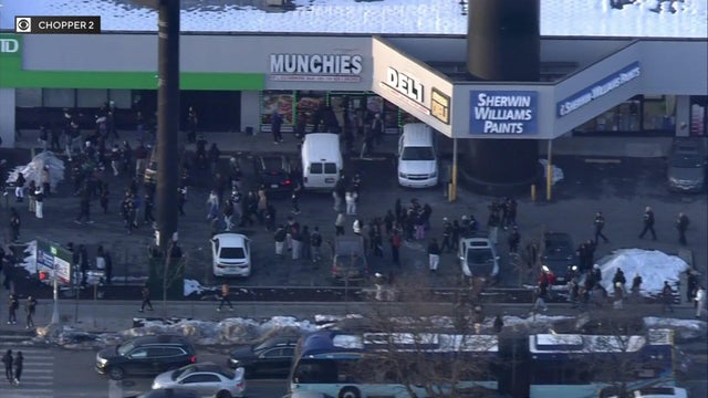 Aerial view of dozens of teenagers around businesses in the Bronx 
