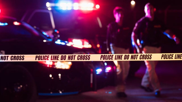Two police officers behind crime scene tape 