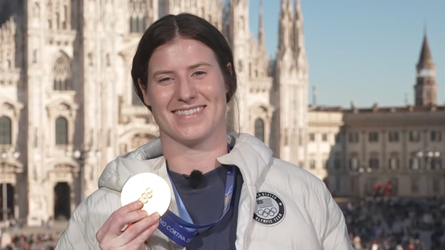 U.S. women's hockey veteran Kelly Pannek holds up Olympic gold medal.