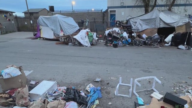 A city street lined with tents and debris 
