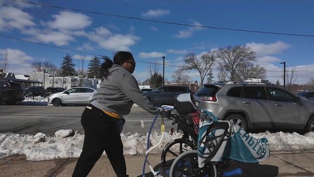 Anita Carrington walks with her son, Ny'Leek Ellison, who is in a wheelchair 