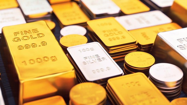 A collection of gold and silver ingots and coins, close up. 