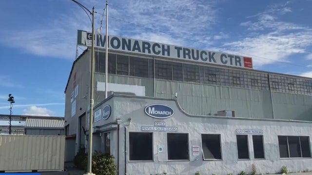 A warehouse with a sign on its roof that reads Monarch Truck CTR 