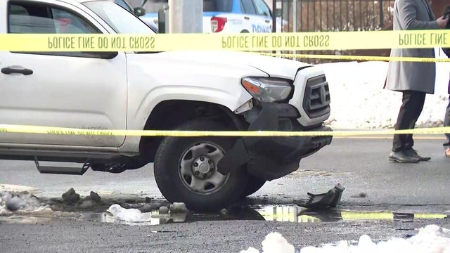Car damaged behind crime scene tape 