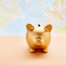 Still life of a golden piggy bank against world map 