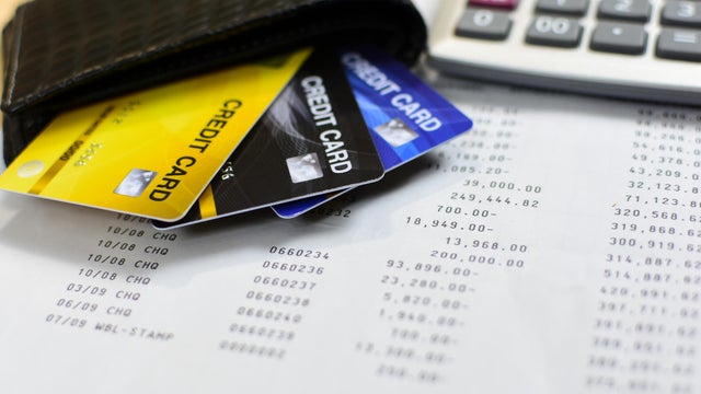 Credit cards in leather wallet and calculator 