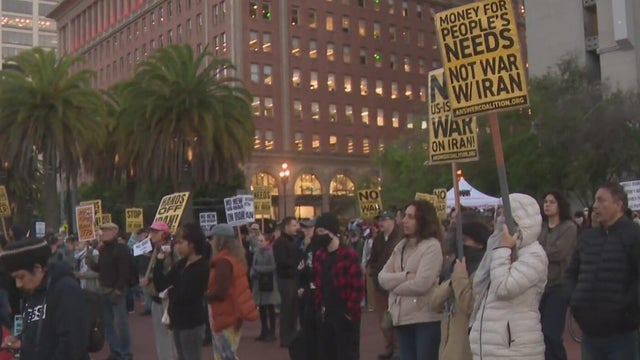 Several people stand with signs at a protest 