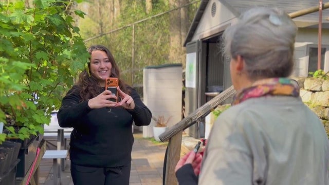 A woman holding a phone to record video 