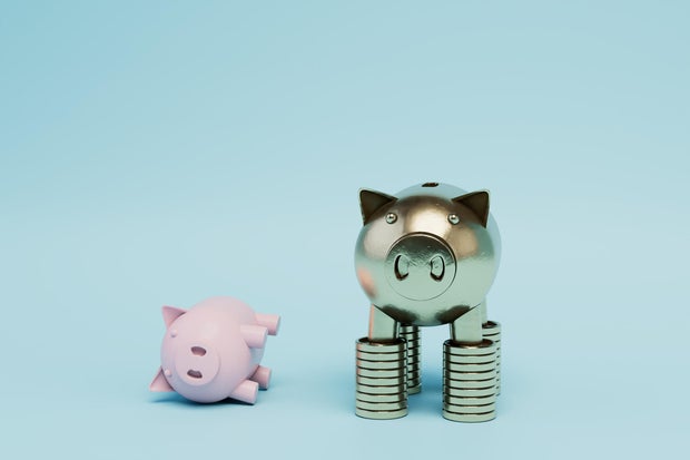 gold piggy bank standing on stacks of gold dollar coins with a piggy bank lying next to it. 3D render 