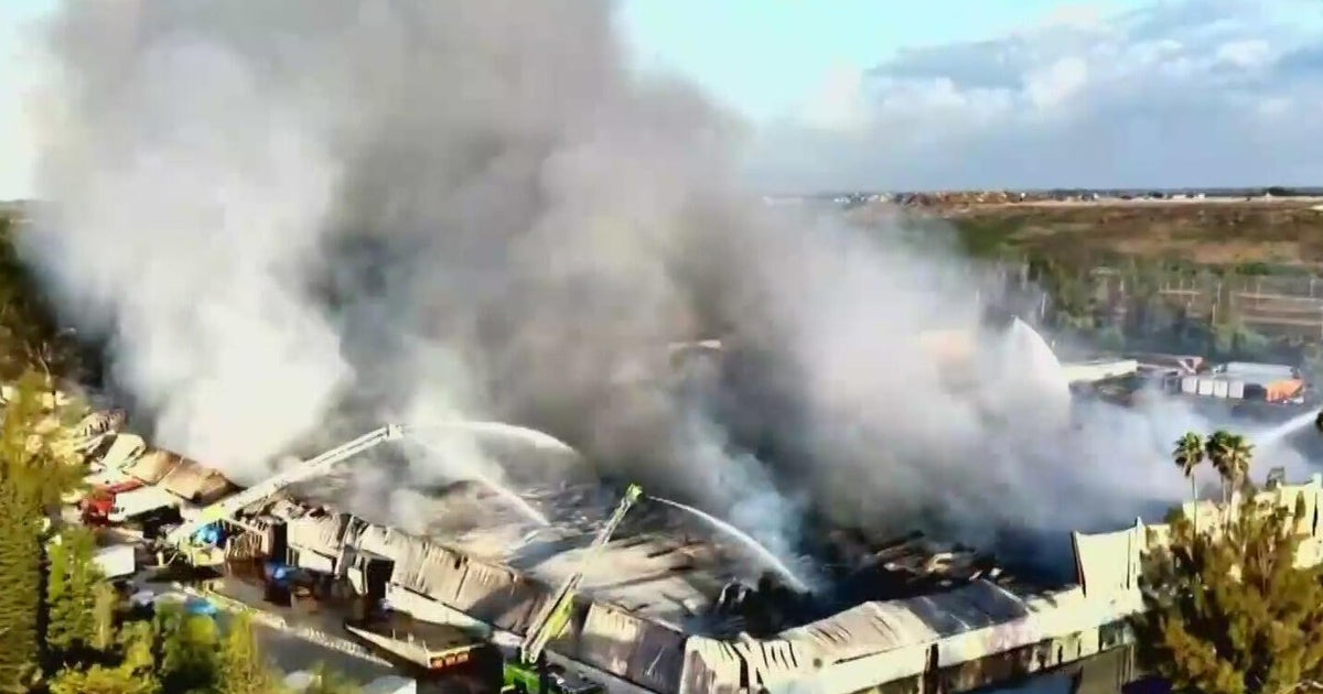 Miami-Dade warehouse fire continues to smolder 24 hours after blaze breaks out