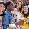Four female friends holding cups of coffee 