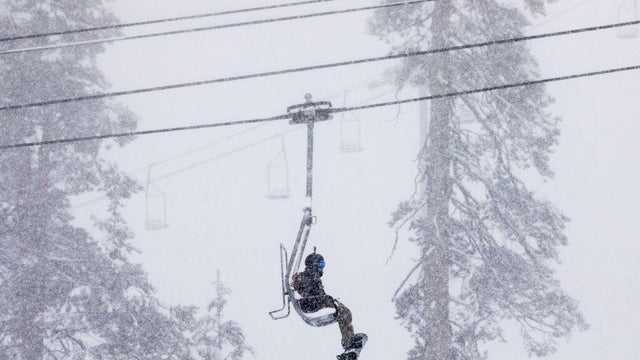 A snowboarder rides the ski lift up the mountain during a moderate snowfall at Sierra-at-Tahoe Resort in Twin Bridges, Calif. Tuesday, April 2, 2019. 