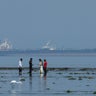FILE PHOTO: Tourists watch marine life, with the MT Desert Kite oil tanker carrying Russian oil in the background, at Narara Marine National Park in the Arabian Sea 