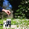 Real estate agent holding keys of new house in a field of daisies 