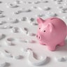 Pink piggy bank standing among white question marks on white background. Illustration of the concept of investment strategies and economic forecast 