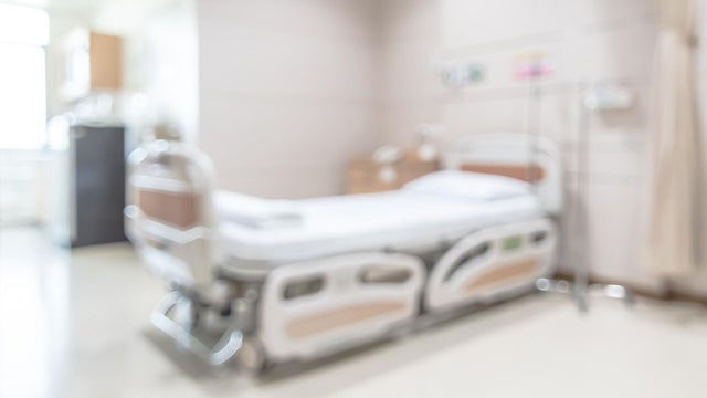 Hospital patient ward or ICU intensive care unit blur background with blurry medical empty bed room interior for nursing care and health treatment service backdrop 