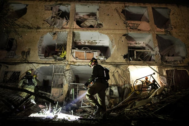 An Israeli soldier uses a torch to inspect the damage after Iranian missile barrages struck Dimona, amid the U.S.-Israel conflict with Iran, in southern Israel
