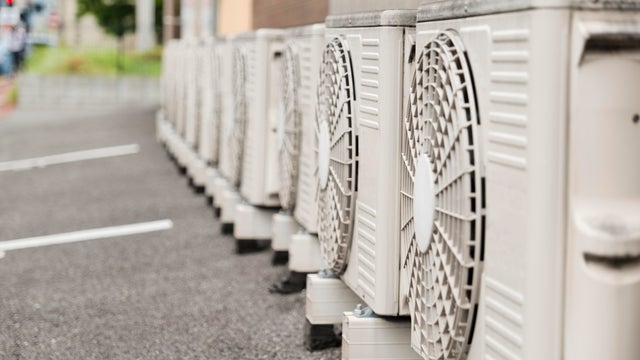 Outdoor Units of Air-Conditioners Lined Up by a Building 