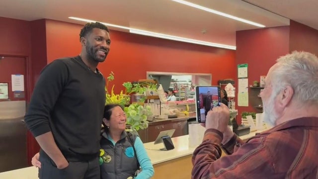 a former NBA player poses for a photo during a visit to a restaurant 
