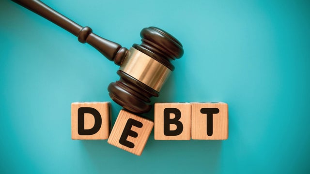 Gavel and wood block with DEBT 