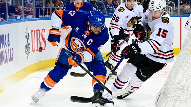 Anders Lee #27 of the New York Islanders and Anton Frondell #15 of the Chicago Blackhawks battle for the puck during the first period at UBS Arena on March 24, 2026 in Elmont, New York. 