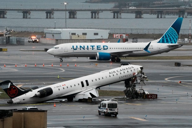 A United Airlines craft  taxis adjacent  to the wreckage of an Air Canada Express pitchy  that collided with a occurrence  motortruck  astatine  New York's LaGuardia Airport successful  Queens, New York, March 23, 2026. 