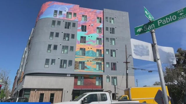 An apartment high rise with a painted mural on its side 