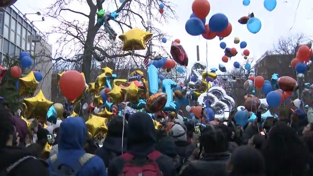Crowd releases balloons 