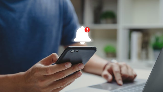 Young man using phone with danger alert. 