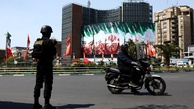 A member of a police force stands guard on a street, amid the U.S.-Israeli conflict with Iran, in Tehran 