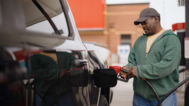 Man fueling truck at gas station pump 
