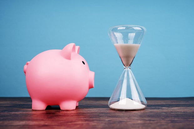 Piggy Bank and Hourglass on Blue Background 