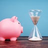 Piggy Bank and Hourglass on Blue Background 