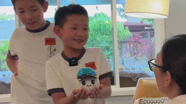 A child holding a plushie designed for a space mission 